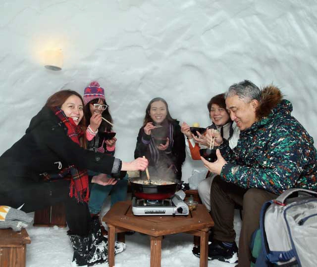 Friends eating hot pot in igloo